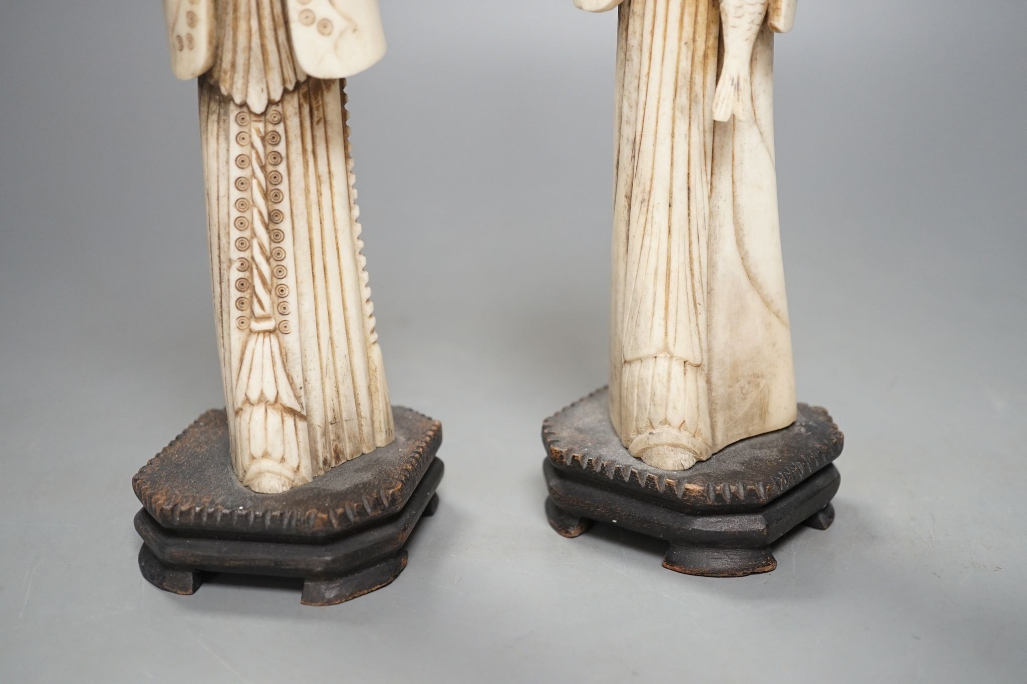 A pair of Chinese carved bone figures, Tallest 27 cms high.